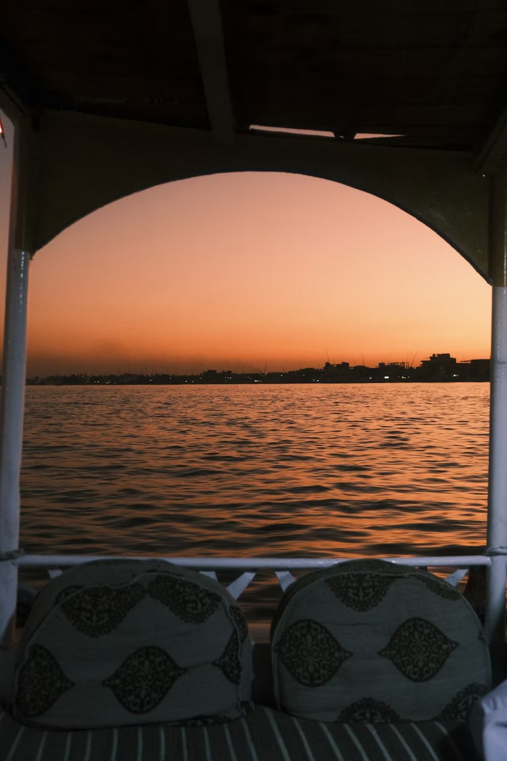 Sunset over the Nile through a dahabiya’s deck arch