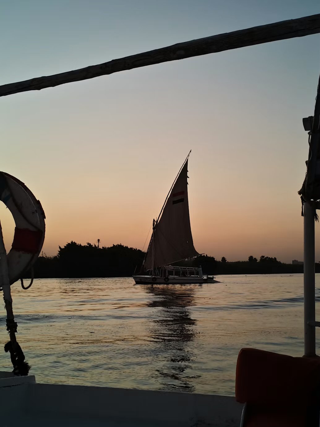 A dahabiya under sail at dusk on the Nile