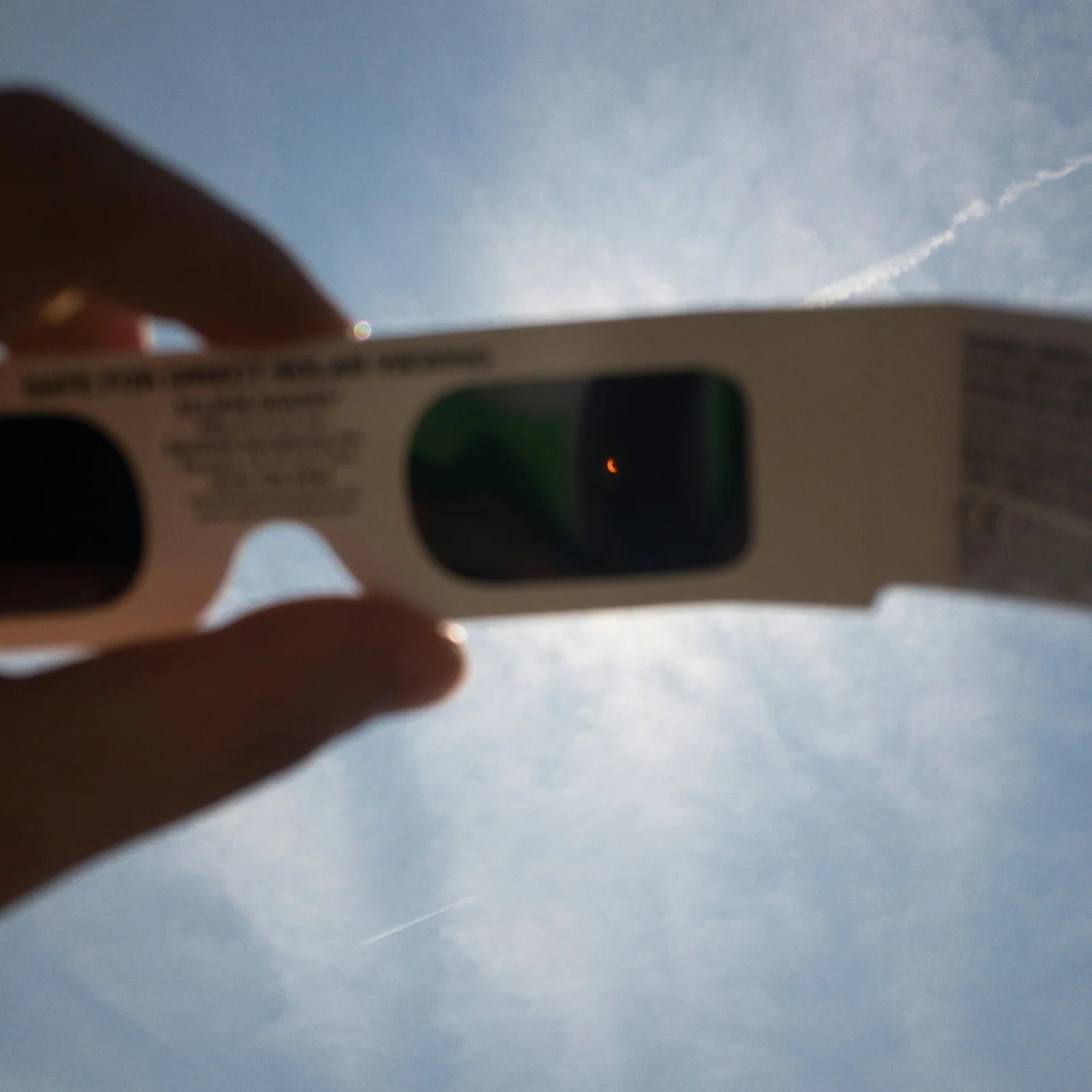 Eclipse glasses held up to the sun